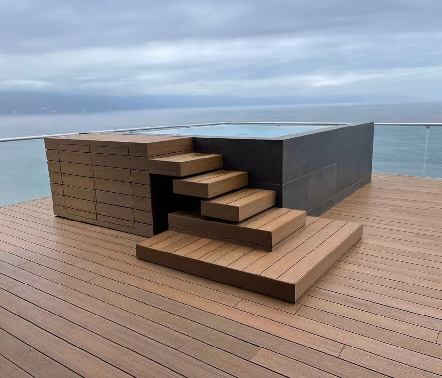 Terraza con jacuzzi elevado y escalones de deck WPC frente al mar