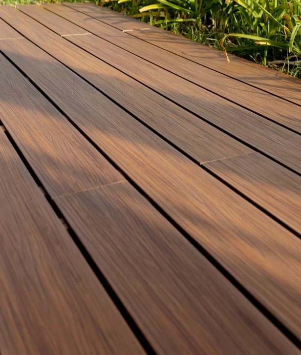 Textura de deck WPC café oscuro con luz de tarde