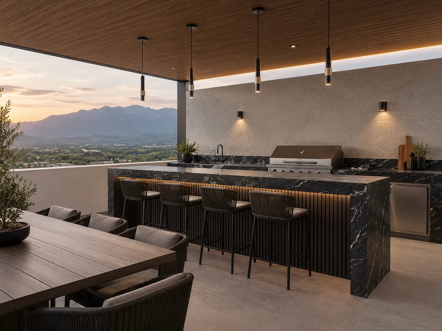 Terraza de una casa con cocina exterior y barra, bajo un techo de lambrín WPC tono madera con luces lineales, y los cerros al atardecer