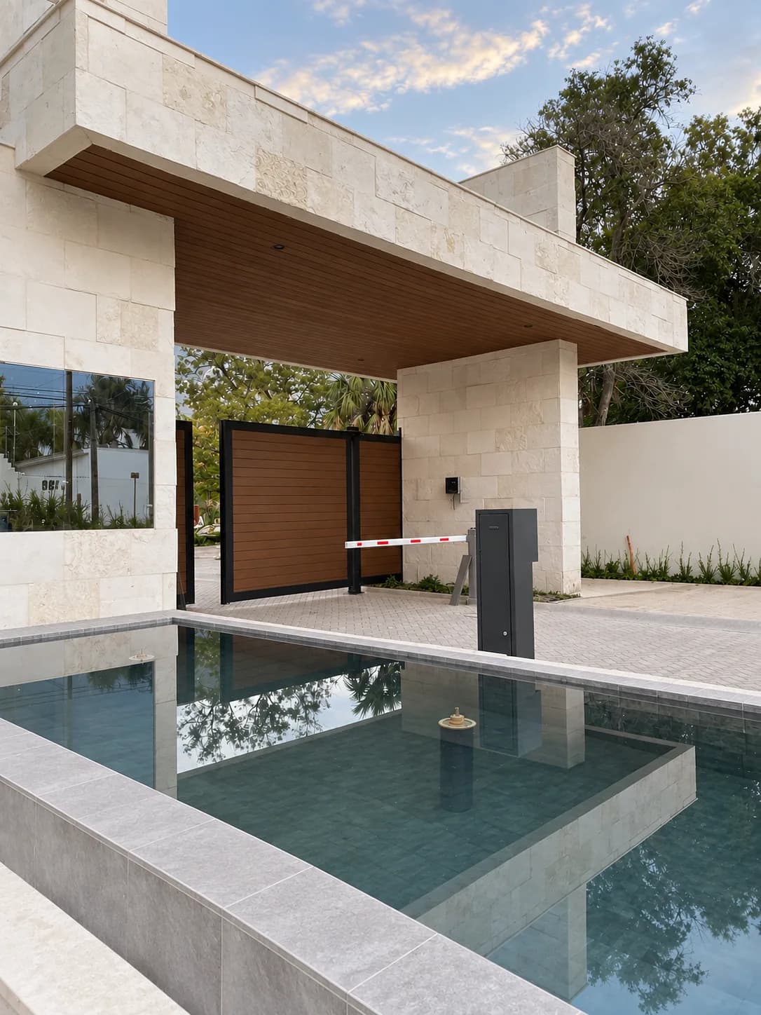 Caseta de acceso de una privada con el techo revestido de Wall Cladding WPC tono madera, un portón tono madera y un espejo de agua al frente